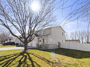View of front of property featuring concrete driveway, fence, an attached garage, a front lawn, and brick siding