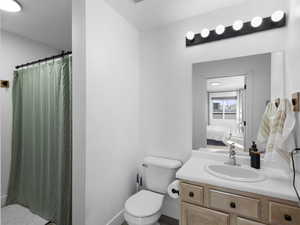 Ensuite bathroom featuring a shower with curtain, toilet, vanity, and ensuite bath