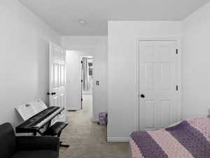 Bedroom featuring light colored carpet and baseboards