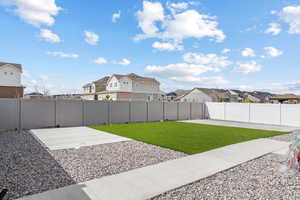 View of yard with a patio, a fenced backyard, and a residential view