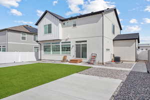 Back of house featuring a gate, fence, board and batten siding, central AC, and a yard