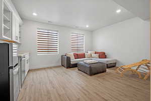 Living room with baseboards, recessed lighting, visible vents, and light wood-style floors