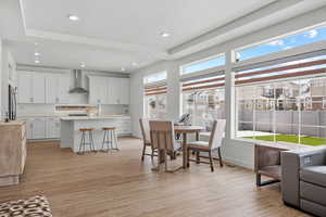 Dining room with light wood-style flooring, baseboards, a healthy amount of sunlight, and recessed lighting