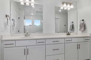 Bathroom with double vanity, visible vents, a sink, and a shower stall