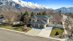 Exterior space featuring driveway, a front yard, stucco siding, fence, and a mountain view