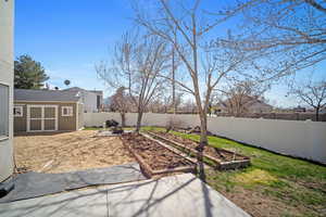 View of yard featuring a fenced backyard and a vegetable garden