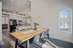 Dining space featuring a towering ceiling, wood finished floors, and recessed lighting