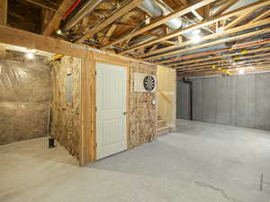 Unfinished basement with stairs and electric panel