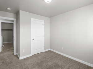 Unfurnished bedroom with carpet floors, baseboards, and a closet