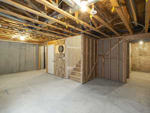 Unfinished below grade area featuring stairway