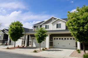 Craftsman inspired home featuring a garage, board and batten siding, and concrete driveway
