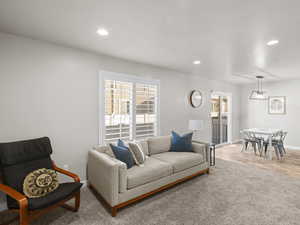 Living area featuring baseboards, light wood-type flooring, and recessed lighting
