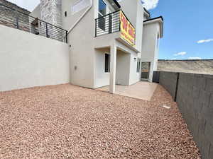 Rear view of property featuring stucco siding, a patio area, and a balcony