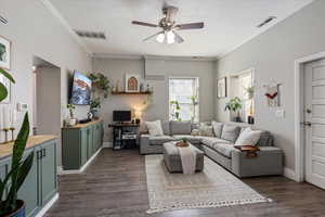 Living area featuring dark wood-style floors, visible vents, and ceiling fan