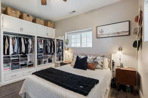 Bedroom featuring a ceiling fan, dark wood-style floors, and visible vents