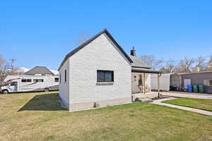 Exterior space featuring a chimney, covered porch, and a yard