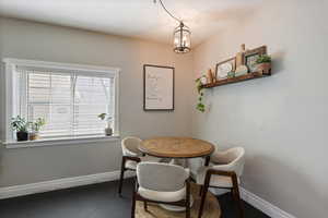 Dining room featuring an inviting chandelier and baseboards