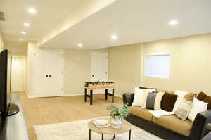 Living area featuring baseboards, recessed lighting, and light colored carpet