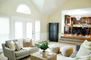 Living room with a chandelier, recessed lighting, and high vaulted ceiling