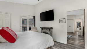 Bedroom featuring wood finished floors, baseboards, arched walkways, and a fireplace