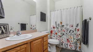 Full bathroom featuring toilet, tile patterned flooring, vanity, and a shower with shower curtain