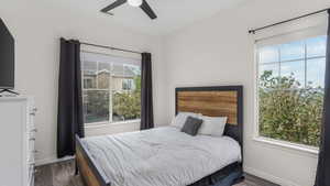 Bedroom featuring dark wood-type flooring, baseboards, and ceiling fan