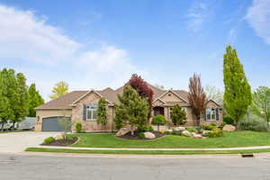 Craftsman house featuring driveway, a garage, a front yard, and stone siding