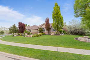 View of front of property with a front yard, cooling unit, and stone siding