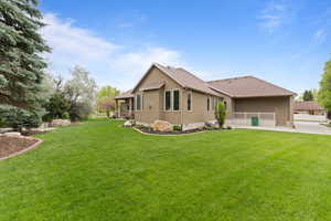 Back of property with a yard and roof with shingles