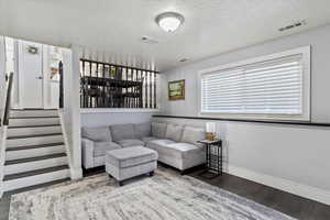 Family room with baseboards, stairs, visible vents, and LVP flooring