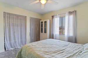 Primary bedroom featuring a ceiling fan and carpet