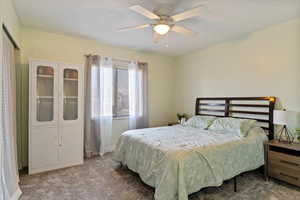 Carpeted primary bedroom featuring ceiling fan