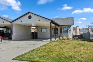View of front of house with a gate, fence, a front lawn, driveway, and a carport