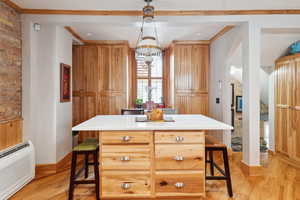 Kitchen with light wood finished floors, a kitchen bar, and baseboards