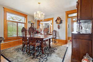 Dining room featuring an inviting chandelier, light wood-type flooring, and baseboards