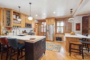 Kitchen with stainless steel appliances, a peninsula, light countertops, and a sink