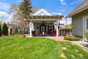 Rear view of house with a patio area, a lawn, fence, a ceiling fan, and an outdoor living space