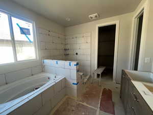 Full bathroom featuring vanity, a garden tub, and visible vents