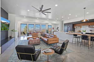 Living area featuring finished concrete floors, recessed lighting, and a ceiling fan