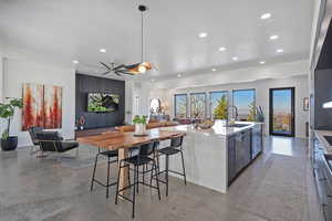 Kitchen featuring open floor plan, concrete flooring, recessed lighting, a sink, and modern cabinets