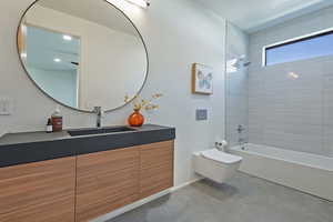 Full bathroom with toilet, vanity, tub / shower combination, and finished concrete floors