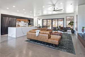 Living area with recessed lighting, a ceiling fan, and finished concrete floors