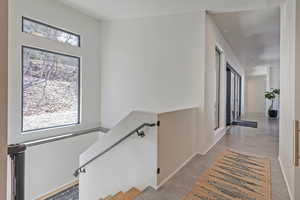 Corridor with baseboards and an upstairs landing