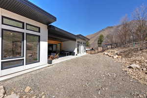 View of yard featuring a mountain view, fence, and a patio