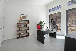 Office area featuring concrete flooring and baseboards