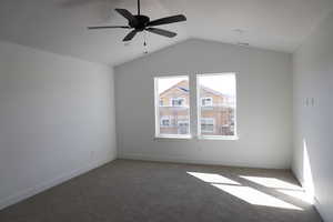 Unfurnished room with carpet flooring, baseboards, vaulted ceiling, and visible vents