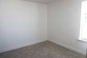 Empty room with baseboards and carpet
