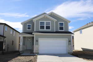 Craftsman inspired home with an attached garage, stone siding, and concrete driveway