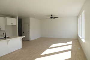 Interior space featuring baseboards, light wood-style floors, ceiling fan, and a sink