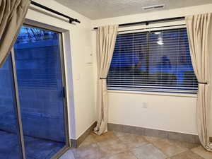 Interior space featuring baseboards, visible vents, and a textured ceiling